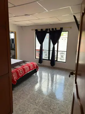 a bedroom with a bed and two large windows at Hotel y Restaurante More in Supía