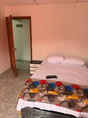 a bedroom with a bed with a blanket on it at Hotel y Restaurante More in Supía