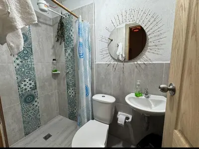 a bathroom with a toilet and a sink and a mirror at Hostal Prana in Abejorral