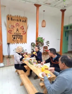a group of people sitting around a wooden table at Hostal Prana in Abejorral