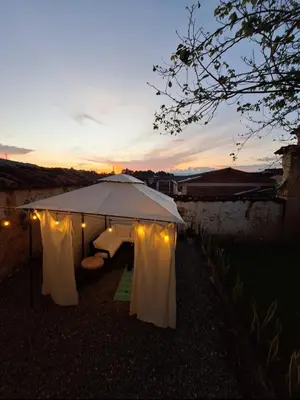 a white tent with lights and a sunset in the background at Hostal Prana in Abejorral