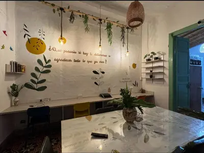 a room with a table with a writing on the wall at Hostal Prana in Abejorral