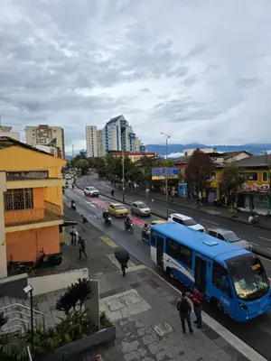 a blue bus driving down a busy city street at Apartaestudio con vista a AV Santander Manizales in Manizales