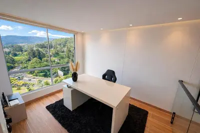 an office with a white desk and a large window at El Poblado Two-Level Luxury Penthouse Amazing View in Medellín