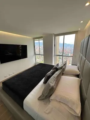 a bedroom with a large bed with a flat screen tv at El Poblado Two-Level Luxury Penthouse Amazing View in Medellín
