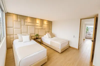 a bedroom with two beds and a mirror at El Poblado Two-Level Luxury Penthouse Amazing View in Medellín