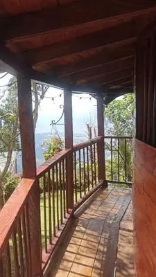 a wooden porch with a view of the ocean at Cabaña Privada Pachamama Ancestral in Medellín