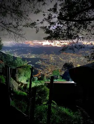 a view of a city from a hill with a fence at Cabaña Privada Pachamama Ancestral in Medellín