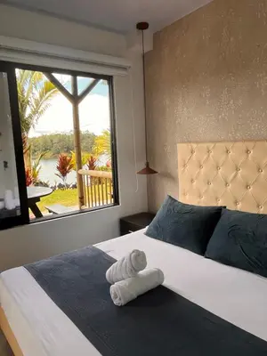 a bedroom with a large bed with a window at Entre Aguas Hotel in Guatapé