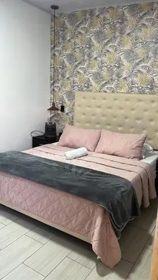a bedroom with a large bed with a pink blanket at Entre Aguas Hotel in Guatapé