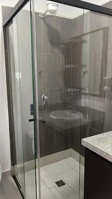 a glass shower in a bathroom with a sink at Entre Aguas Hotel in Guatapé