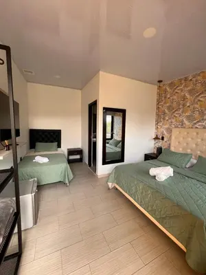 a hotel room with two beds and a mirror at Entre Aguas Hotel in Guatapé