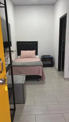 a bedroom with a bed with a pink pillow at Entre Aguas Hotel in Guatapé