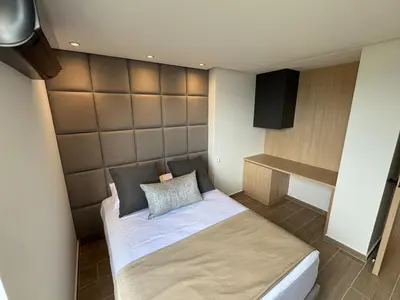 a small bedroom with a bed and a television at El Poblado Amazing Penthouse with Breathtaking Views in Medellín
