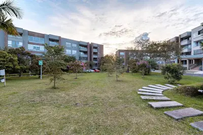 a park with rocks and trees in front of a building at Apartamentos Casa Grande in Rionegro