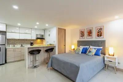 a large bedroom with a bed and a kitchen at Apartamentos La Frontera in Medellín