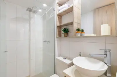 a bathroom with a shower and a toilet and a sink at Apartamentos La Frontera in Medellín