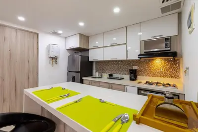 a kitchen with a yellow island in the middle at Apartamentos La Frontera in Medellín