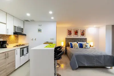a kitchen and a bedroom with a bed in a room at Apartamentos La Frontera in Medellín