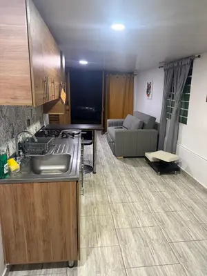 a kitchen with a sink and a living room with a couch at Finca el salvador in Envigado
