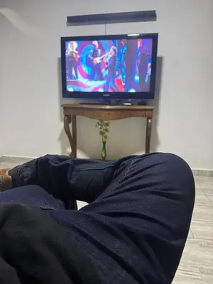 a person laying in bed watching a tv at Finca el salvador in Envigado