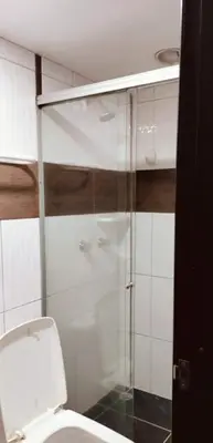 a bathroom with a toilet and a glass shower at Cómodo apartamento por días in Manizales