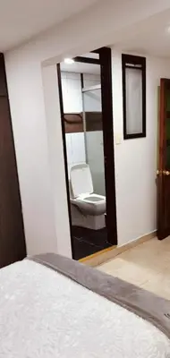 a bedroom with a mirror and a toilet in a room at Cómodo apartamento por días in Manizales