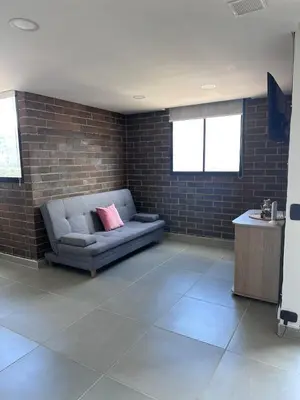 a living room with a couch and a brick wall at Sabaneta, aparta Loft, excelente Ubicacion, Wifi in Sabaneta