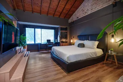 a bedroom with a large bed and a large window at Lleras Vibex Party in Medellín