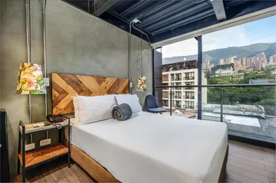 a bedroom with a white bed and a large window at Lleras Vibex Party in Medellín