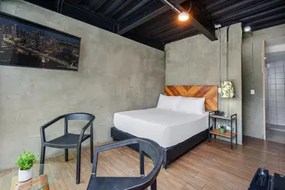 a bedroom with a bed and a chair at Lleras Vibex Party in Medellín