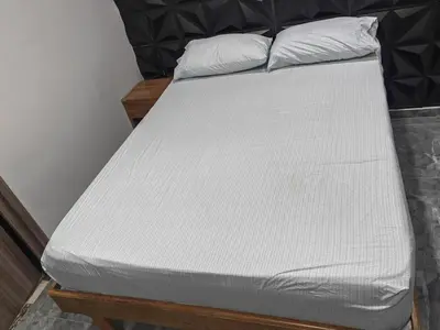 a bed with white sheets on top of it at Quiet space near Nórdica with parking in Bello