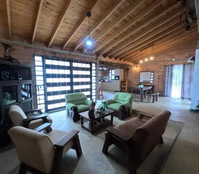 a large living room with green chairs and tables at Villa El Colibri in El Peñol