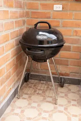 a charcoal grill sitting against a brick wall at Villa El Colibri in El Peñol