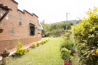 a brick building with a yard with plants at Villa El Colibri in El Peñol