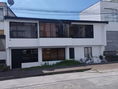 a white building with windows on a street at Hotel Casa Guayacanes in Manizales