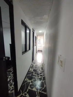 a hallway with a tile floor and a hallway with a door at Hotel Casa Guayacanes in Manizales