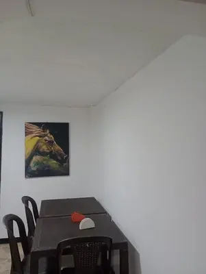 a dining room table with a painting of a horse at Hotel Casa Guayacanes in Manizales
