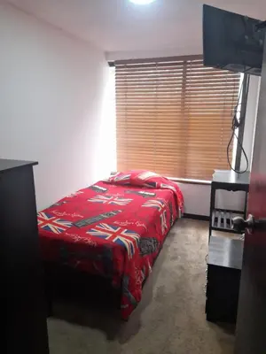 a bedroom with a red bed in a room with a window at Hotel Casa Guayacanes in Manizales
