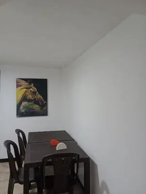 a dining room table with a painting of a horse at Hotel Casa Guayacanes in Manizales