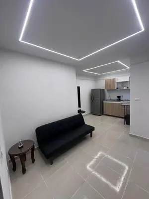a living room with a black couch and a table at Hermoso y acogedor apartamento in Medellín