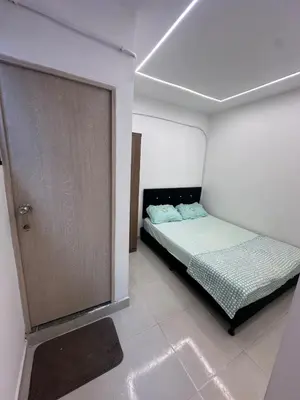 a small bedroom with a bed and a door at Hermoso y acogedor apartamento in Medellín