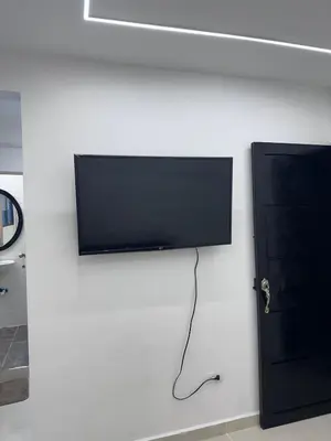 a flat screen tv on a wall next to a door at Hermoso y acogedor apartamento in Medellín