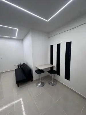 a room with two chairs and a table and a wall at Hermoso y acogedor apartamento in Medellín