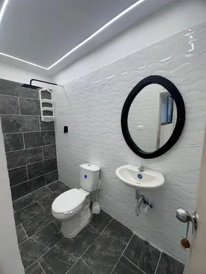 a bathroom with a toilet and a sink and a mirror at Hermoso y acogedor apartamento in Medellín