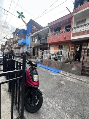 a red scooter is parked next to a fence at Hermoso y acogedor apartamento in Medellín