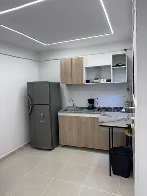 a kitchen with a refrigerator and a table in it at Hermoso y acogedor apartamento in Medellín
