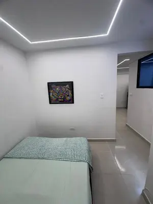 a bedroom with a bed and a painting on the wall at Hermoso y acogedor apartamento in Medellín
