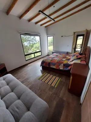 a bedroom with a bed and a couch in a room at El Encanto - El Peñol in Chiquinquirá