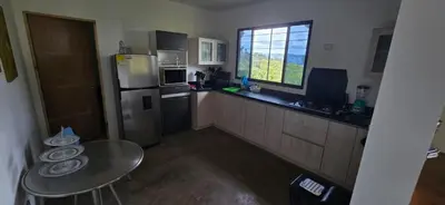a small kitchen with a table and a refrigerator at El Encanto - El Peñol in Chiquinquirá